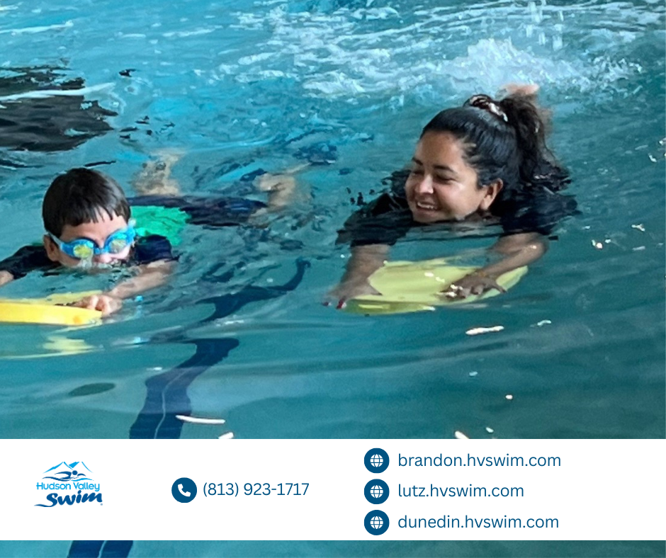 teacher showing a kid how to swim in a pool on a boogie board